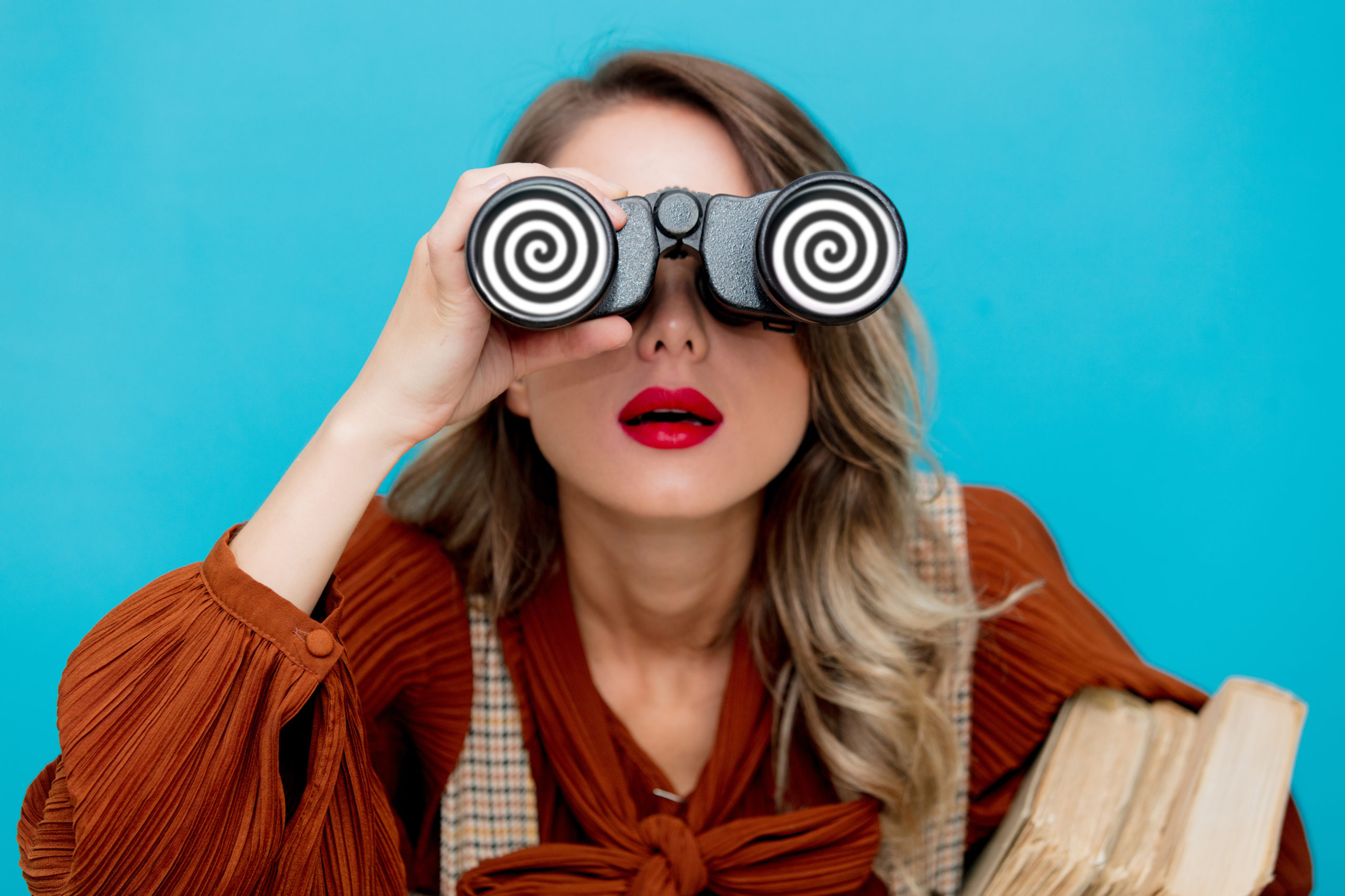 Woman looking through binoculars with swirl lenses